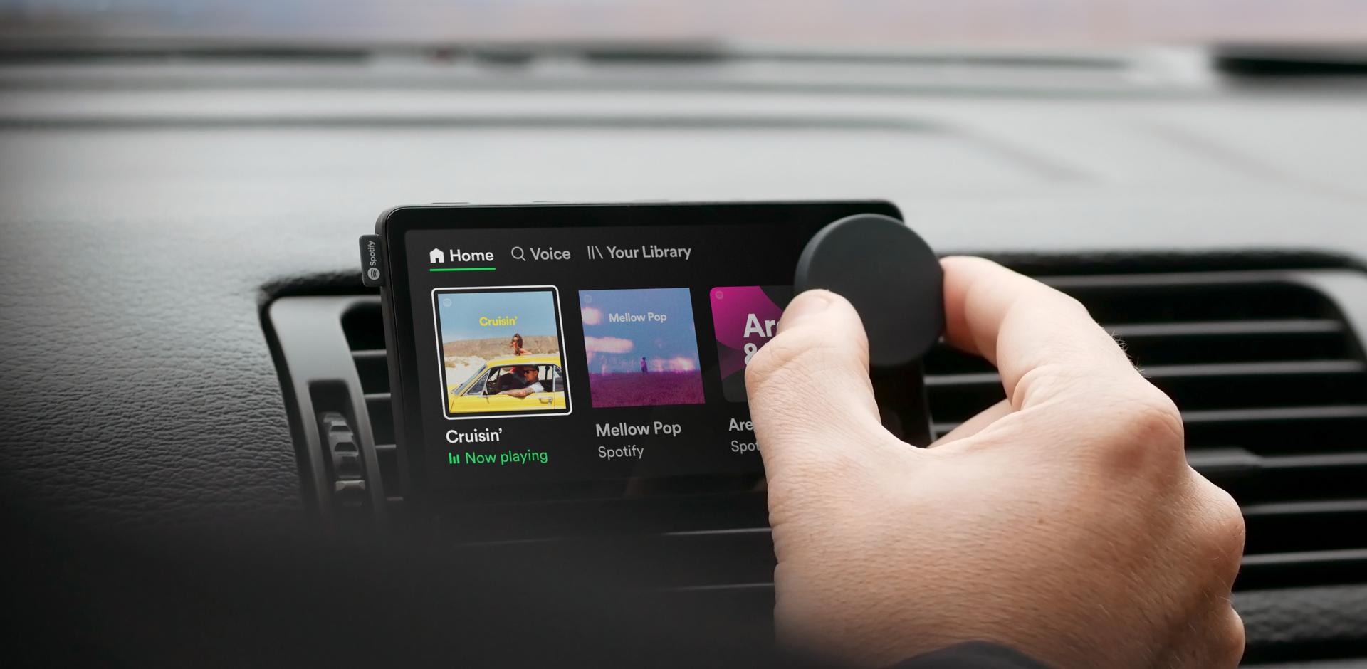 Man turning control wheel on spotify car thing