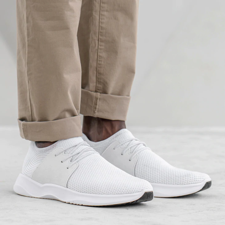 man with rolled up pants wearing white alessi shoes