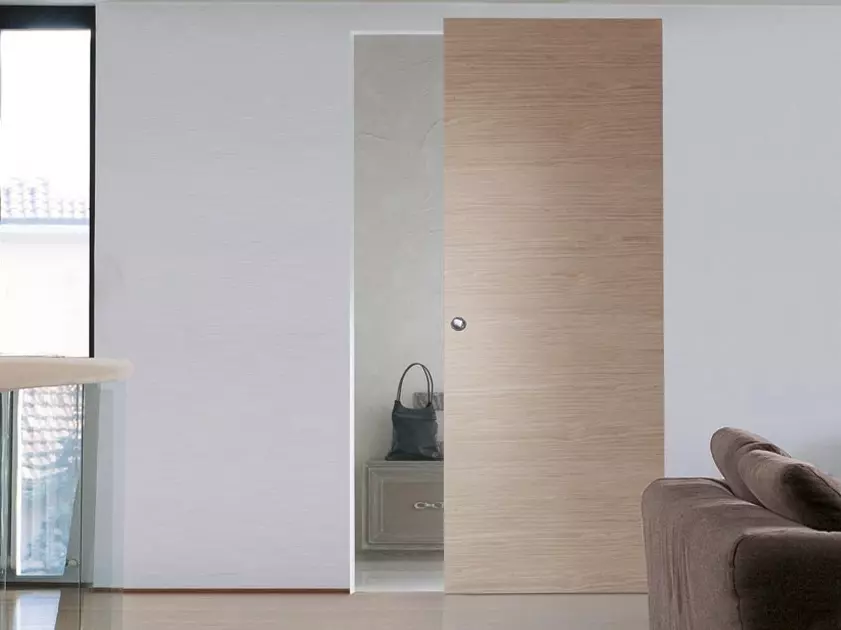 light colored sliding door with wheels visible on wall