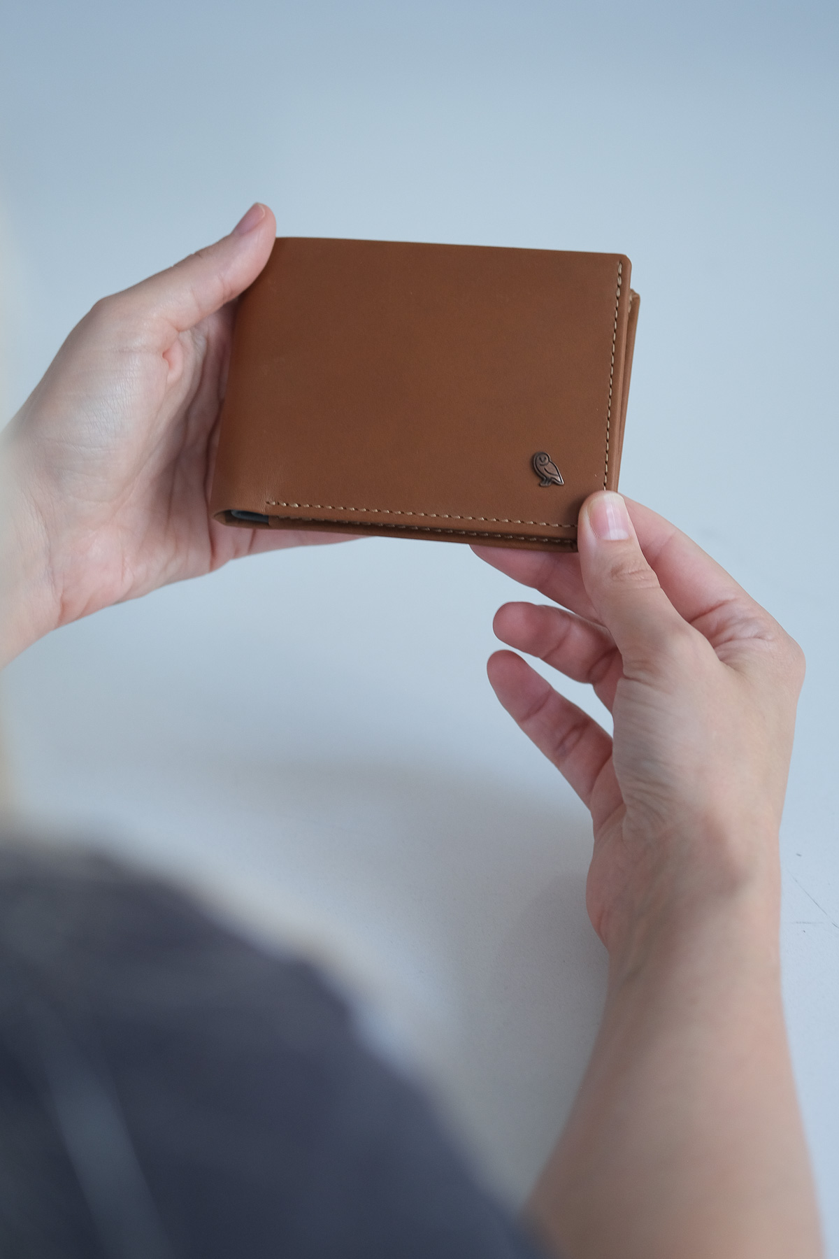 Woman holding brown bellroy wallet