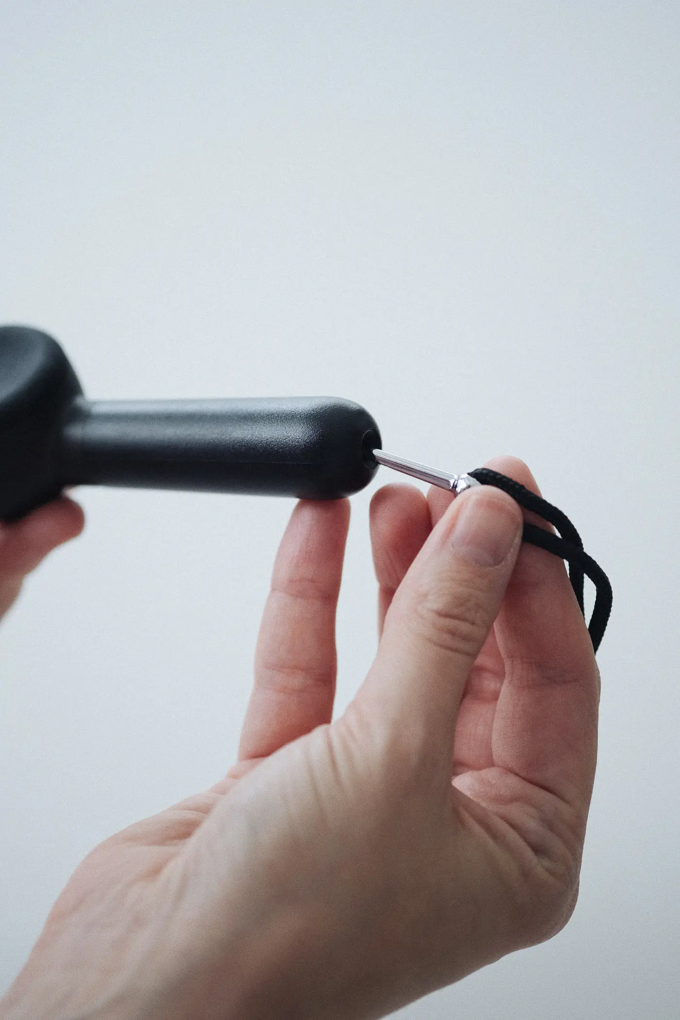 woman putting cleaning tool inside of heir handpipe