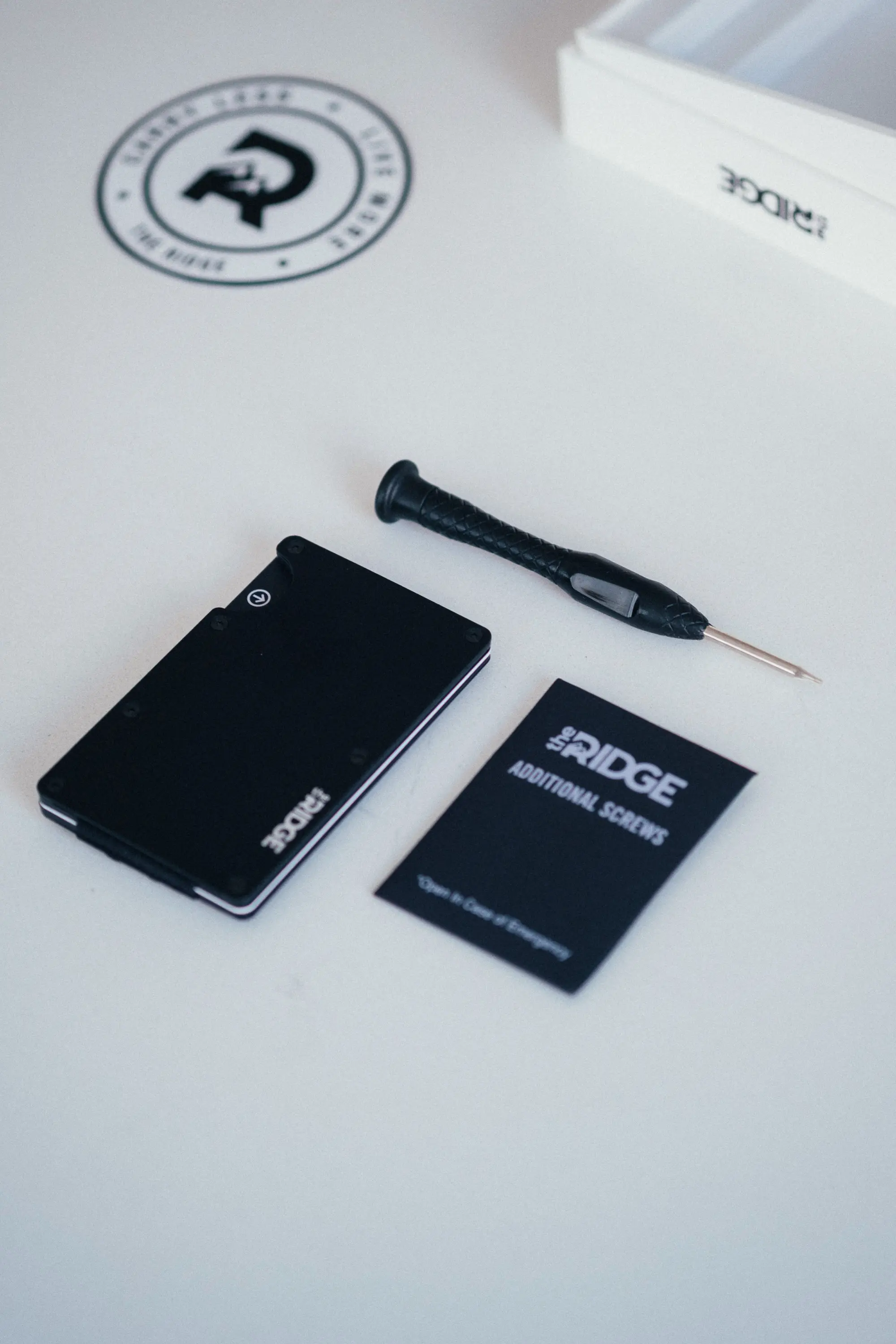 Ridge wallet package contents with sticker, screwdriver and wallet on counter