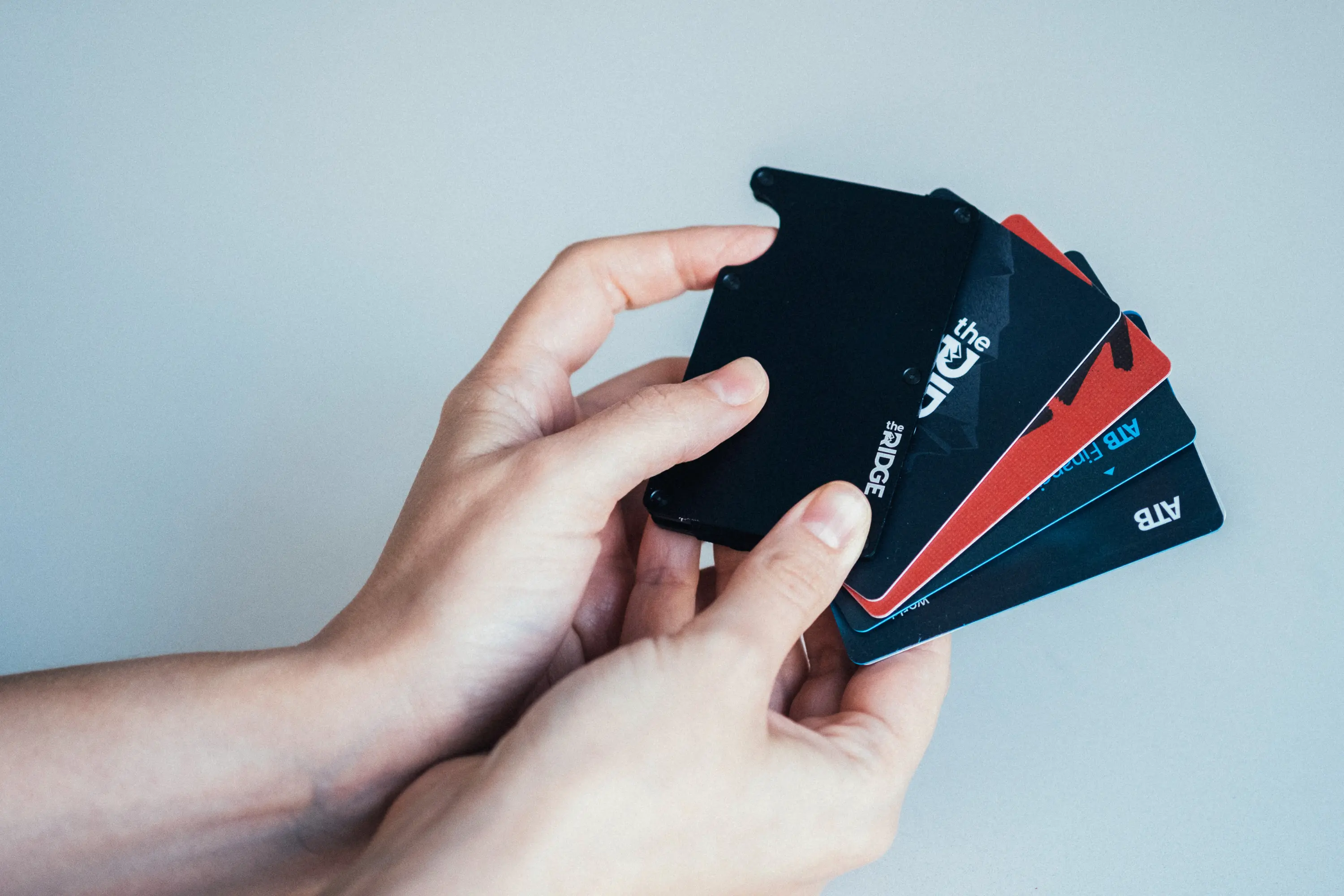 Woman holding up cards coming out of the ridge wallet