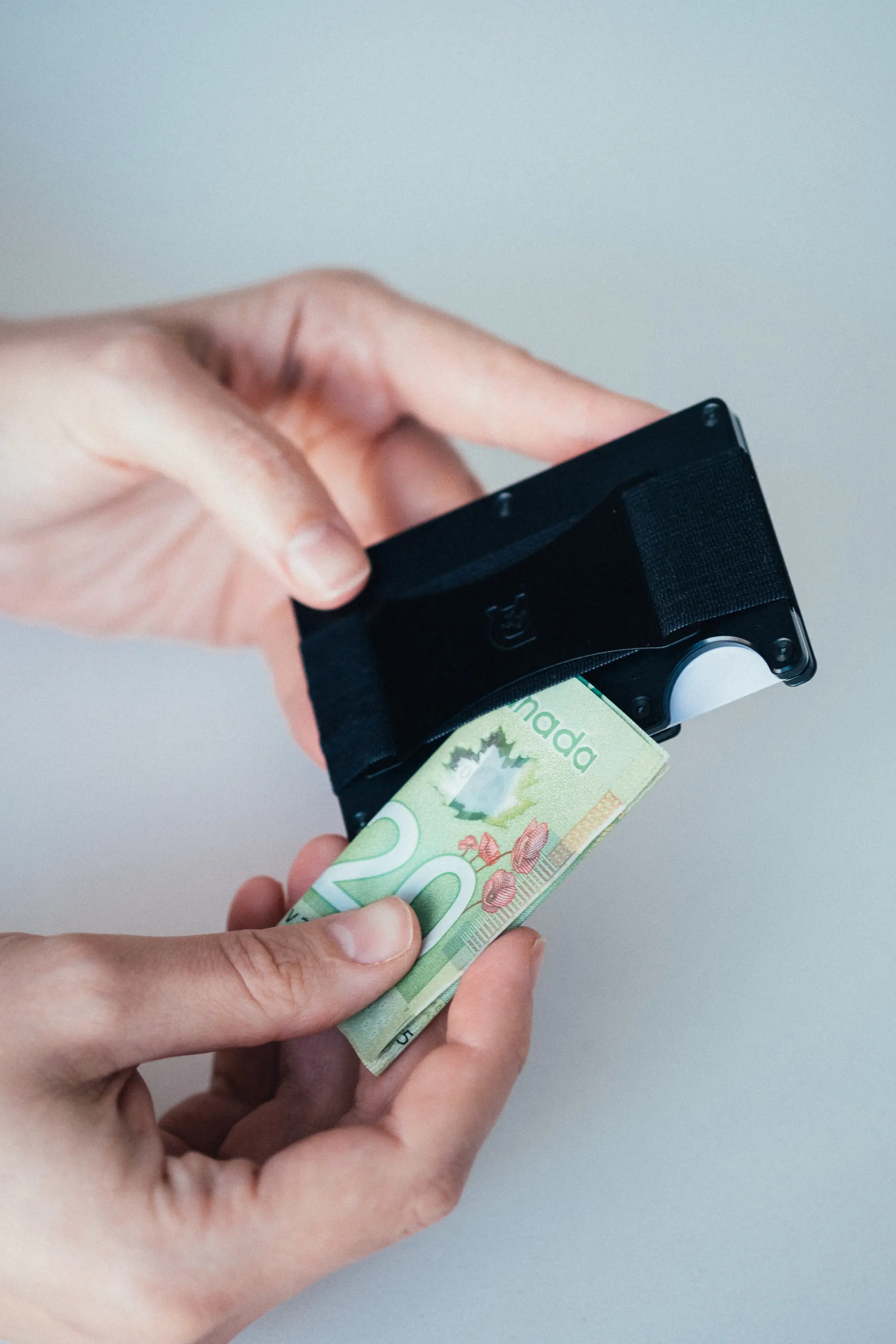 Woman putting $20 into ridge wallet clip
