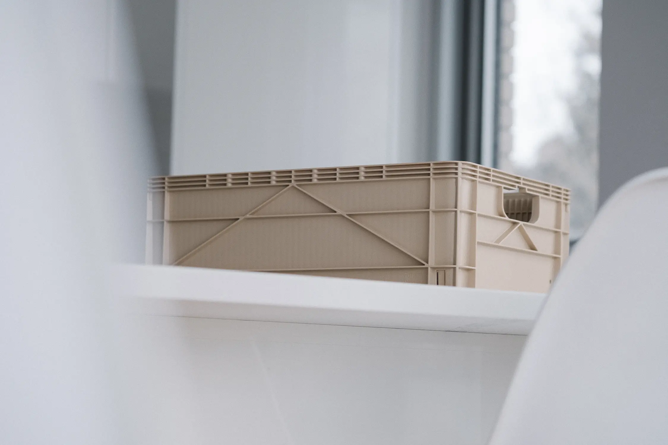 low angle of small tan colored plastic storage crate