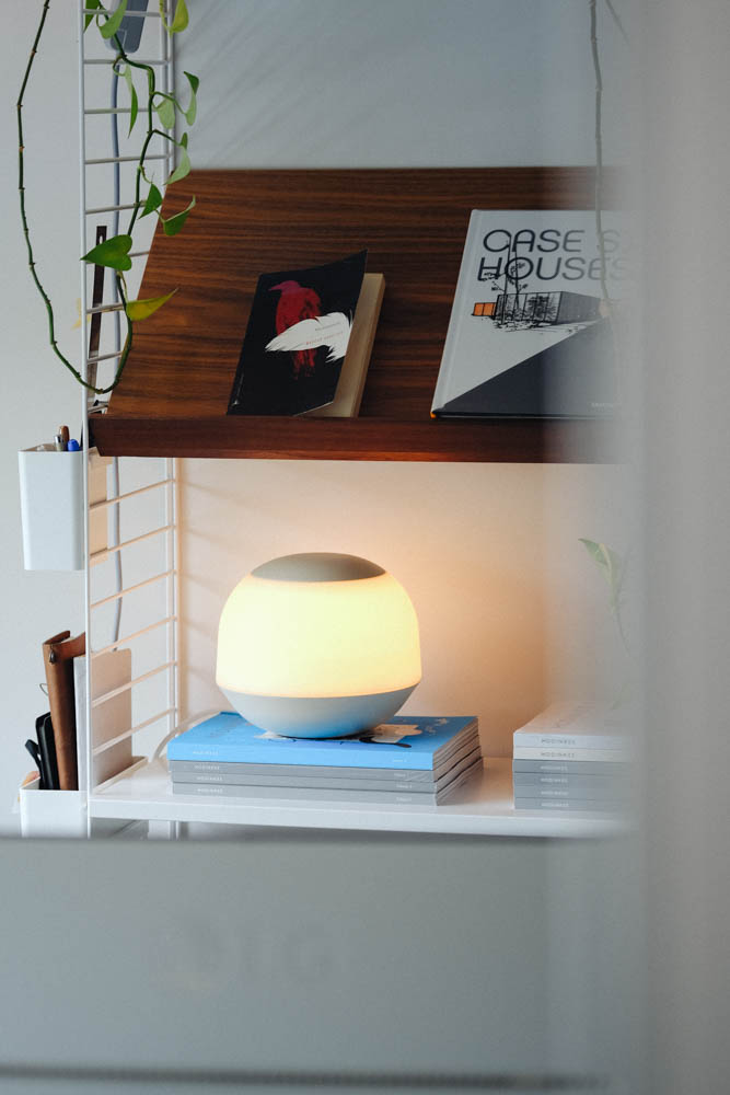Photo of lamp on a shelf with books visible.