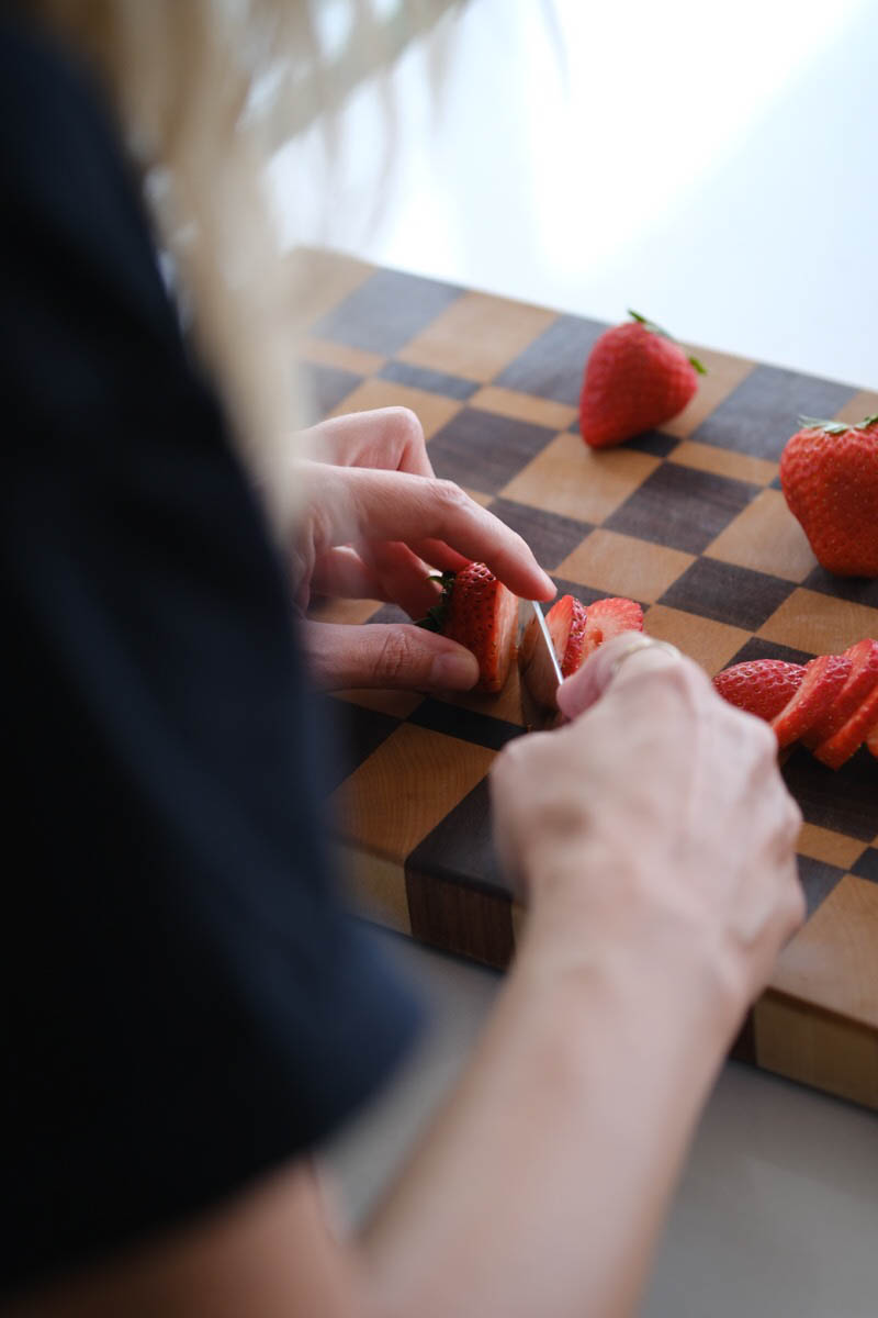 Woman slicing strawberries on a cutting board